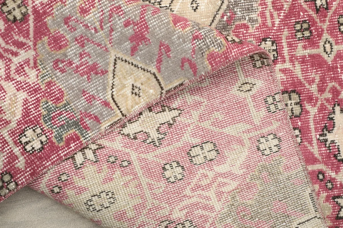 Detailed view of the rug's reverse, revealing the knotting and color variations