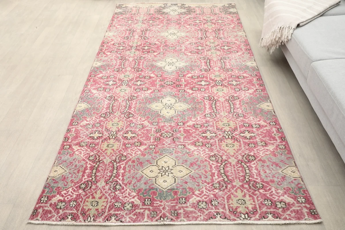 Overhead view of the vintage rose and gray geometric rug in a room setting
