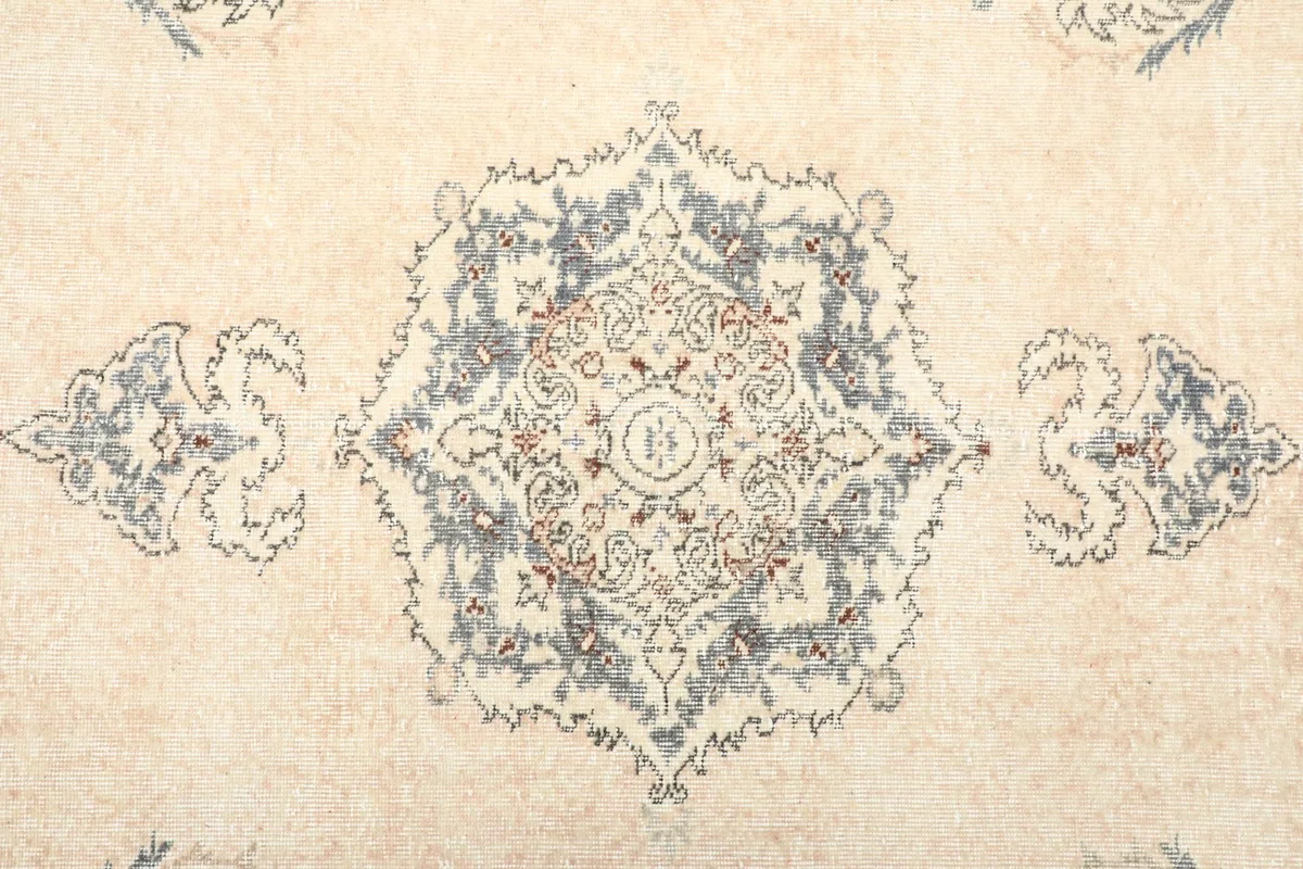 Close-up of the central medallion design with blue and brown accents