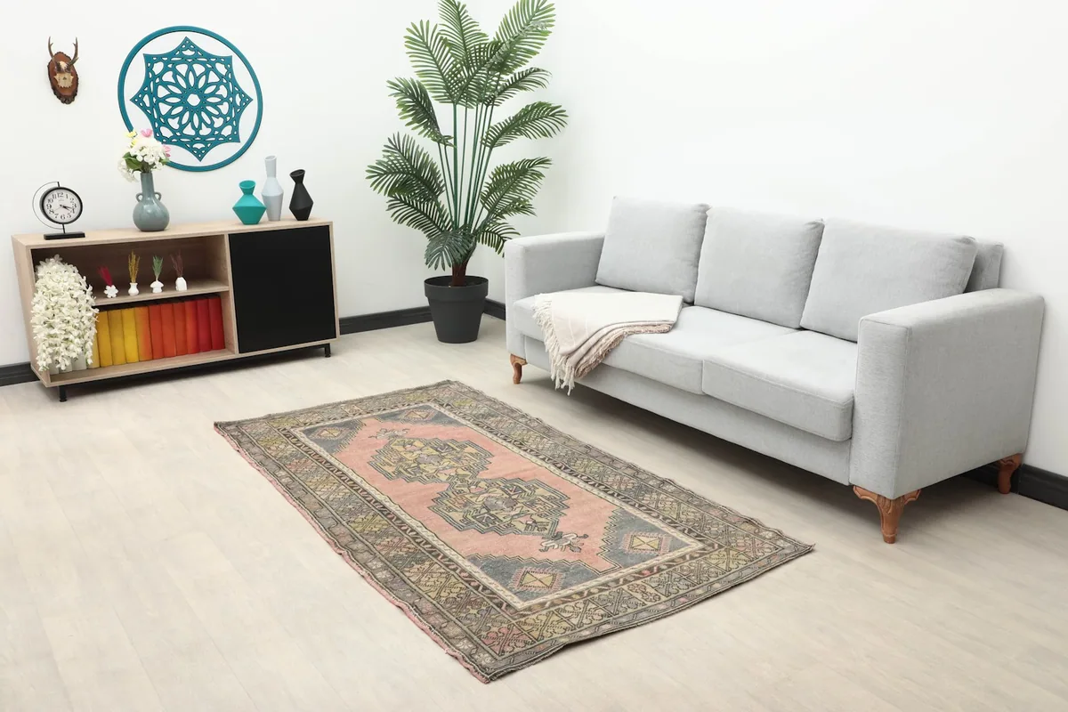 Rose geometric area rug placed in a modern living room setting with a gray sofa and light wood floor.