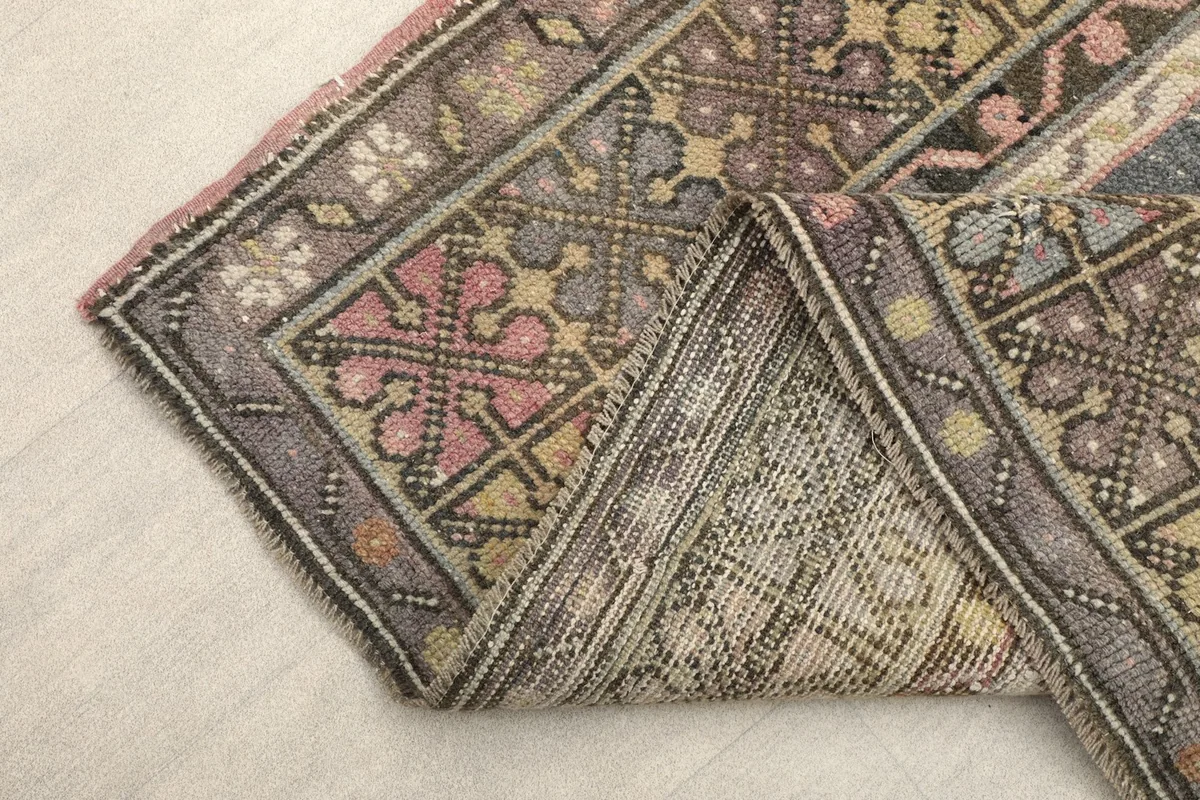 View of the rug folded to show the backside (foundation) and the hand-knotted construction.