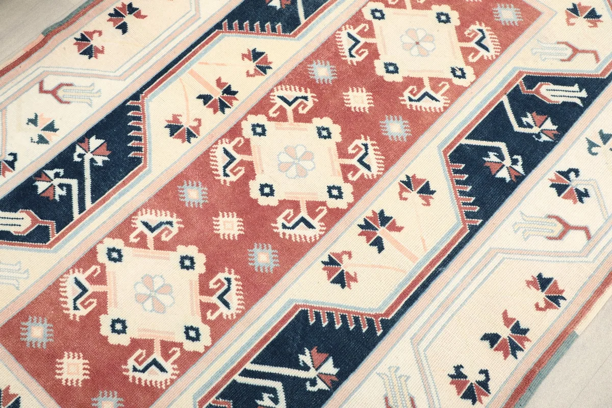 Detailed angled view of the central rust field and surrounding navy and ivory motifs