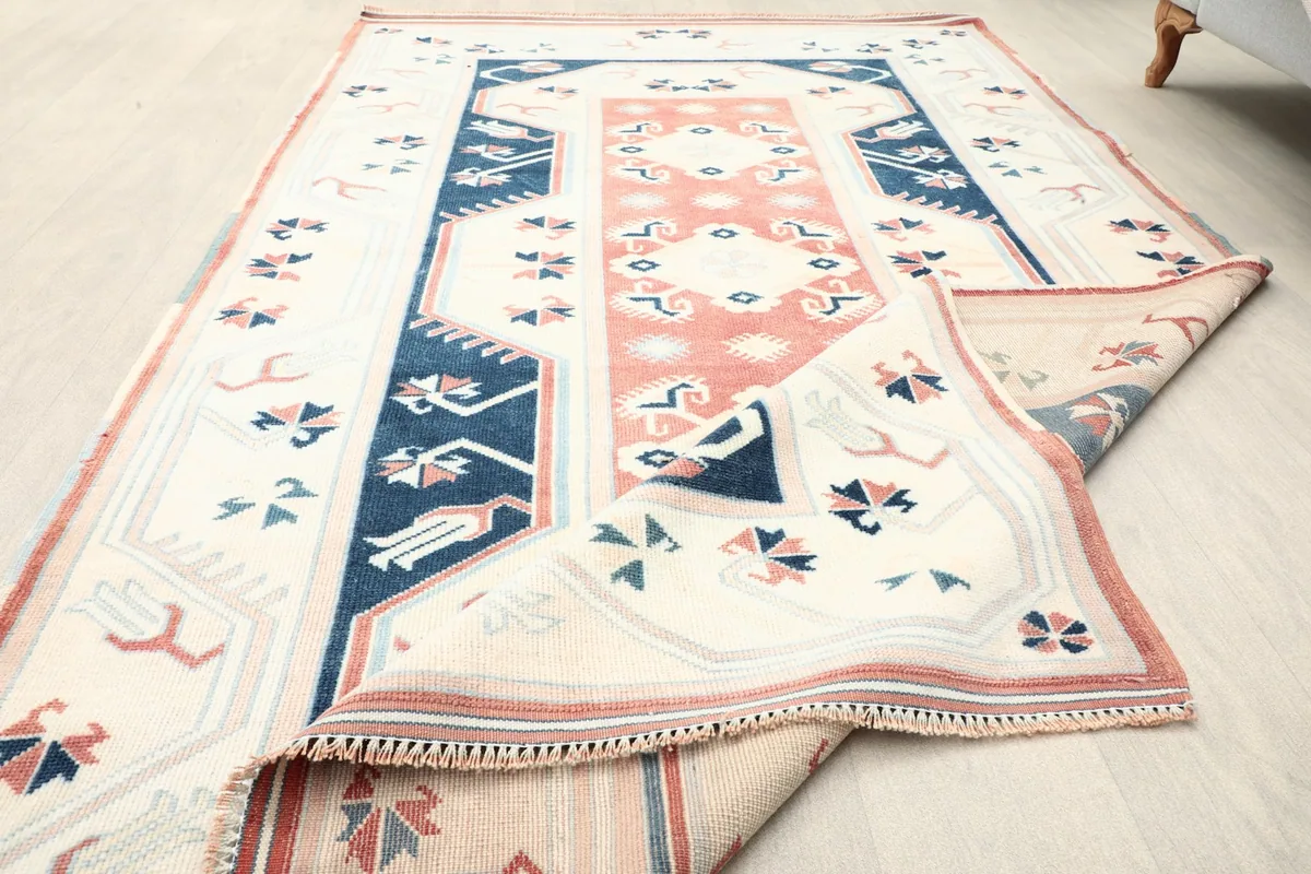 Partial fold showing the low pile and texture of the vintage wool rug