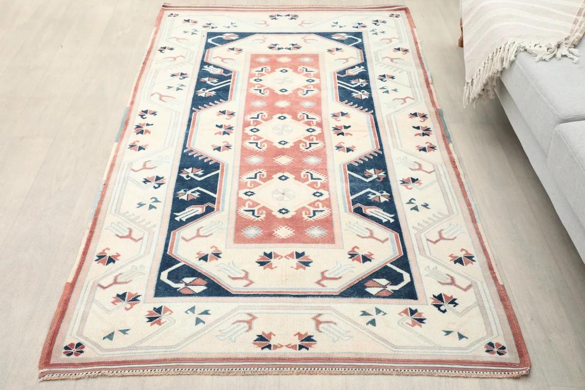 Overhead view of the vintage ivory and rust rug on a light floor