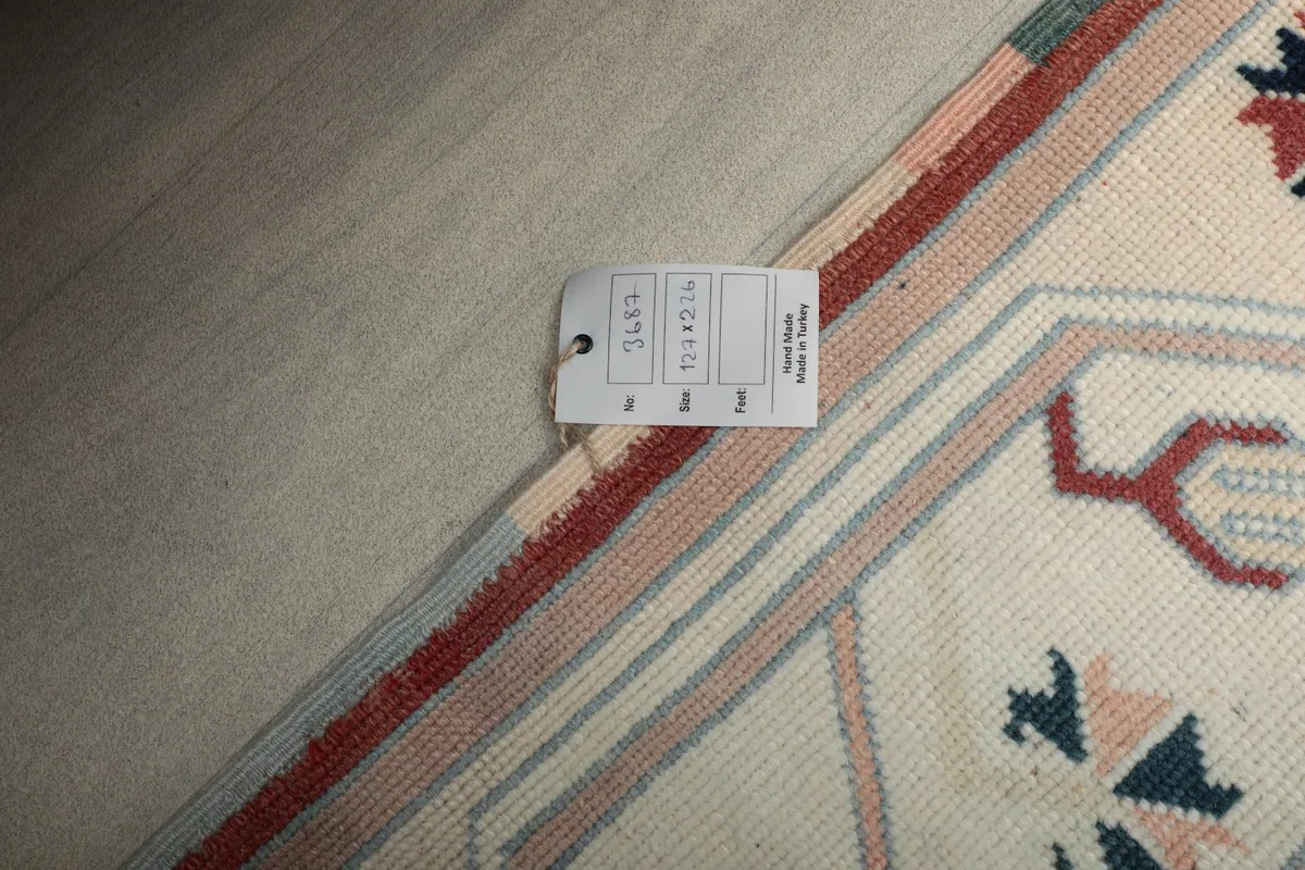Product tag indicating the rug's size and origin, lying on the rug's surface