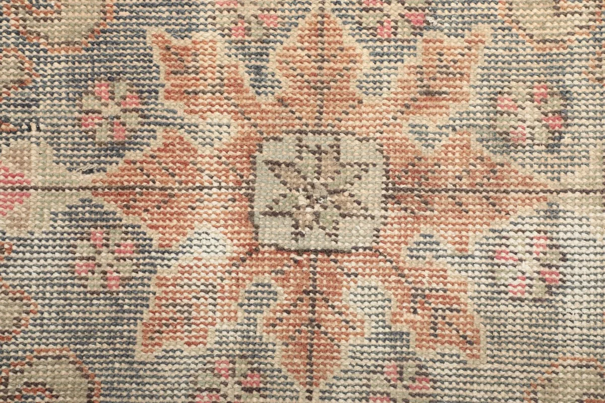 Extreme close-up showing the low wool pile and hand-knotted texture of the rug