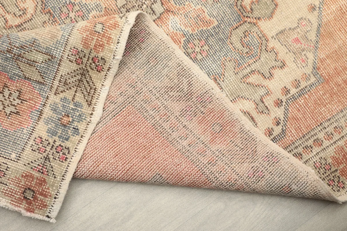 View of the rug's back and a folded section, showing the cotton foundation