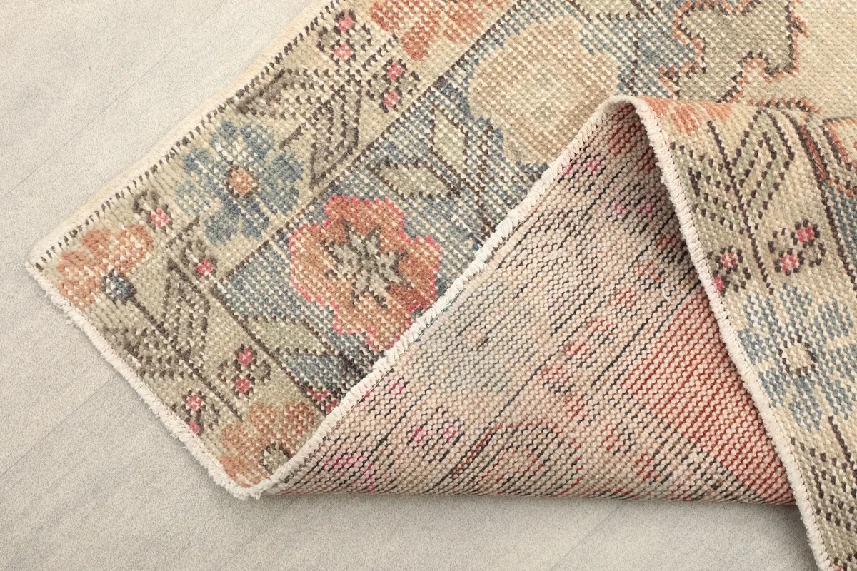 Folded corner of the rug revealing the back and the density of the hand-knotted weave