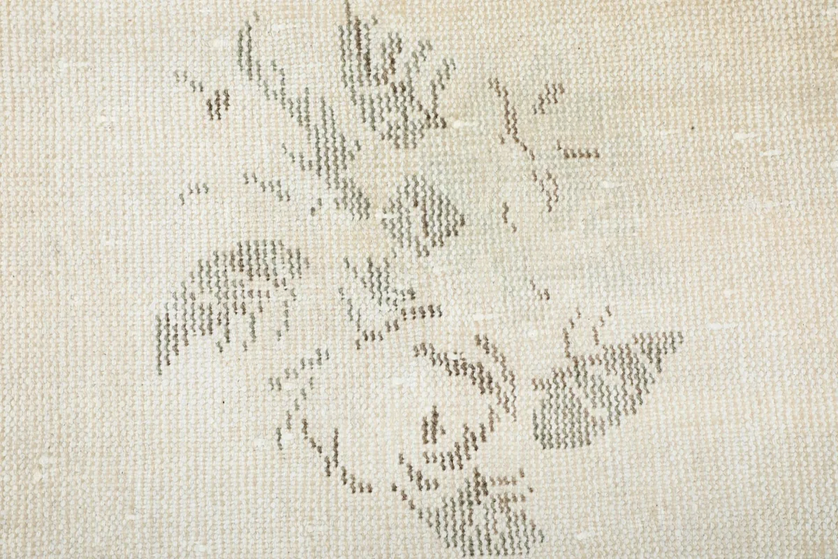 Macro shot of the rug's weave, illustrating the intricate details of the gray floral design.