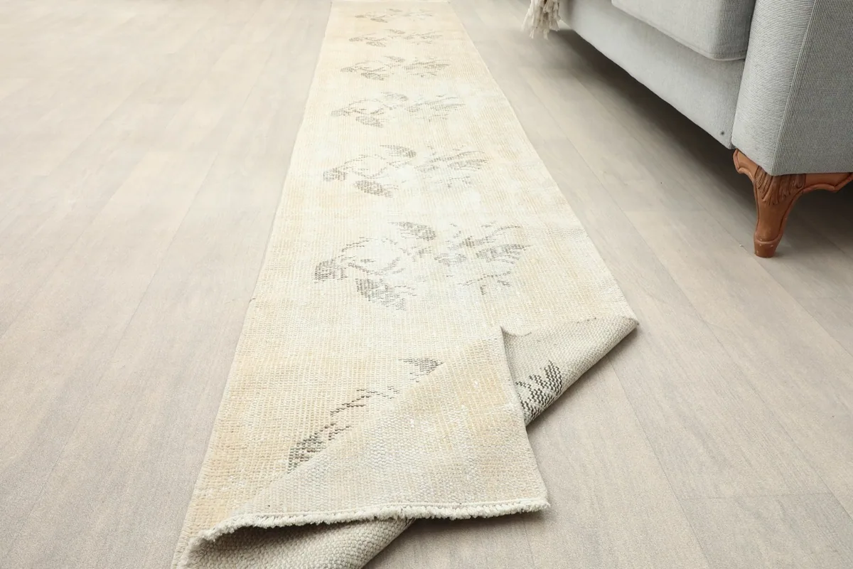 Runner rug with a corner folded back, displaying the underside and overall construction.