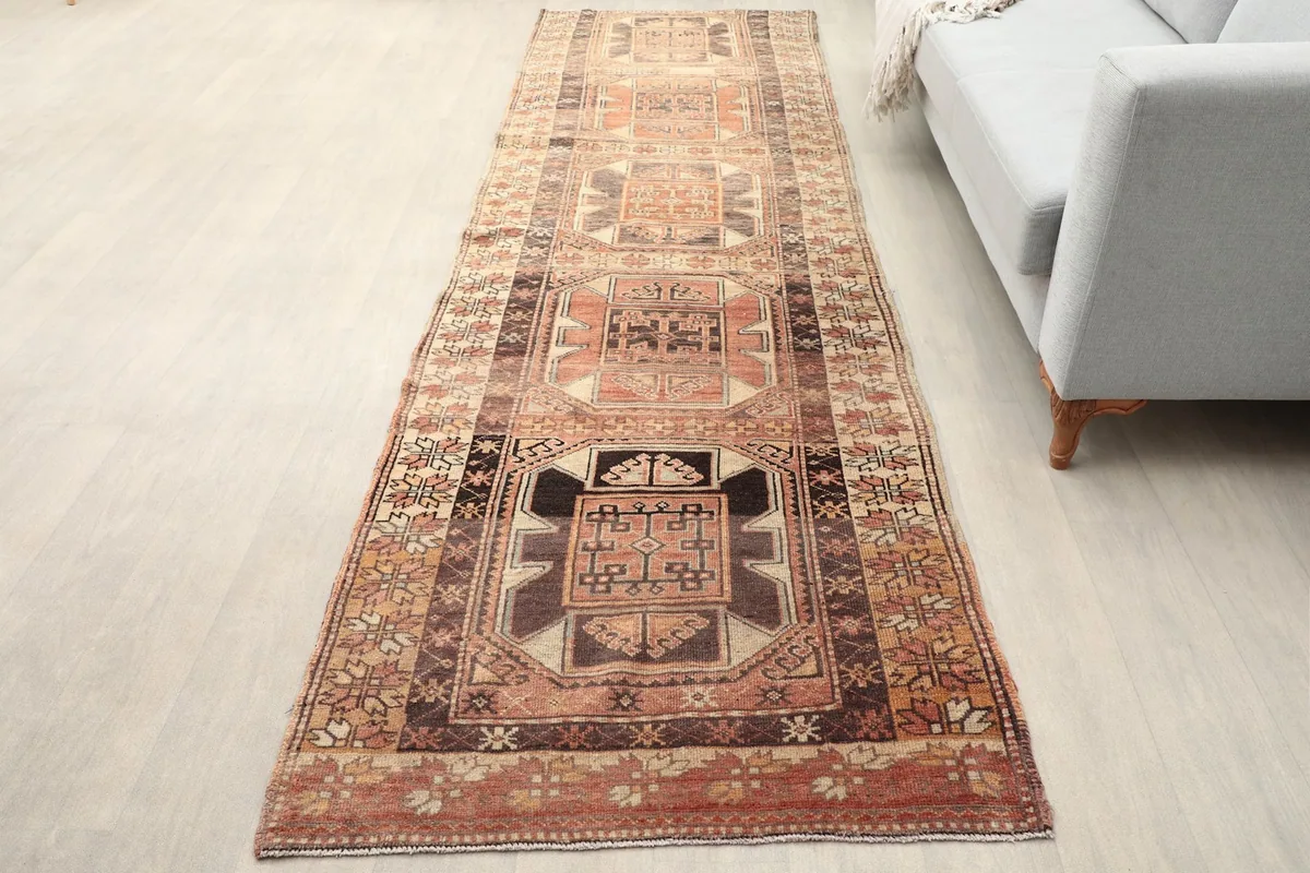 Vintage Anatolian runner displayed in a hallway setting next to a light gray sofa