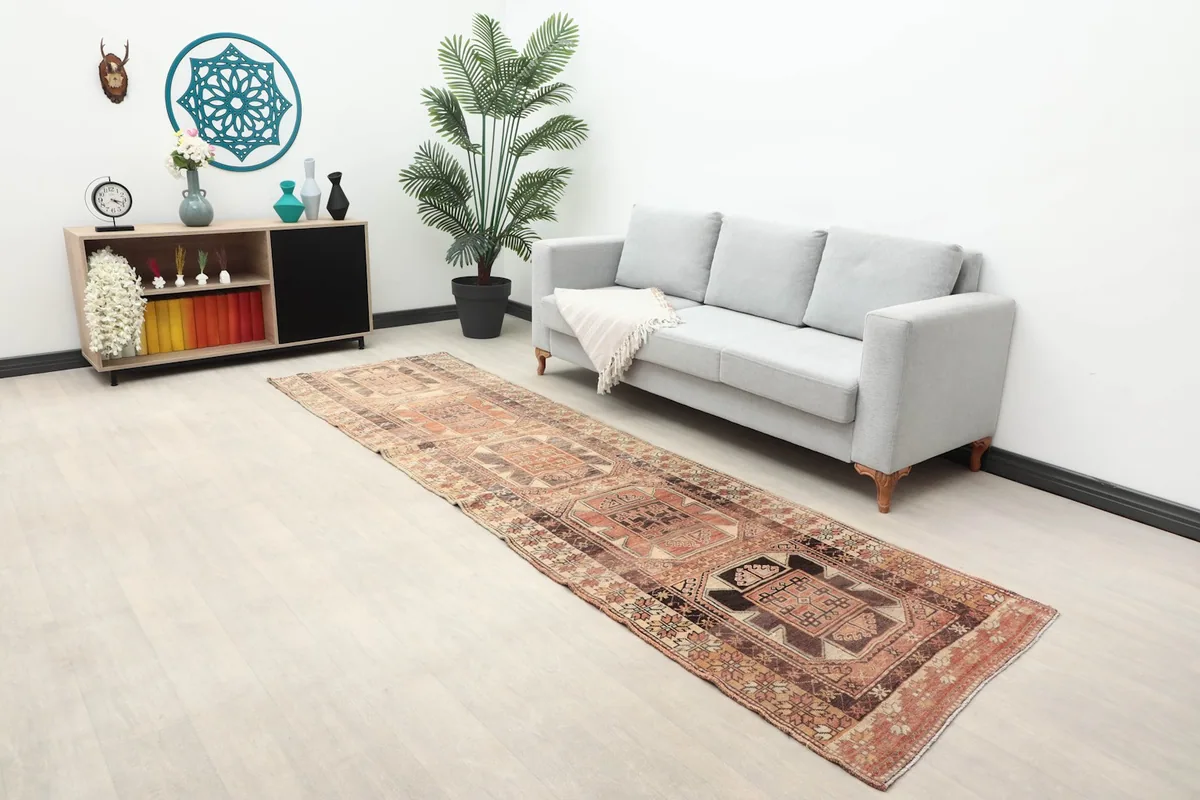 Long view of the rust and brown runner in a living space with a sofa and console table