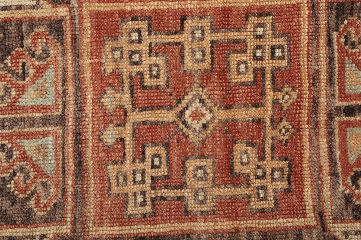 Texture and low pile of the hand-knotted wool, highlighting the intricate geometric design