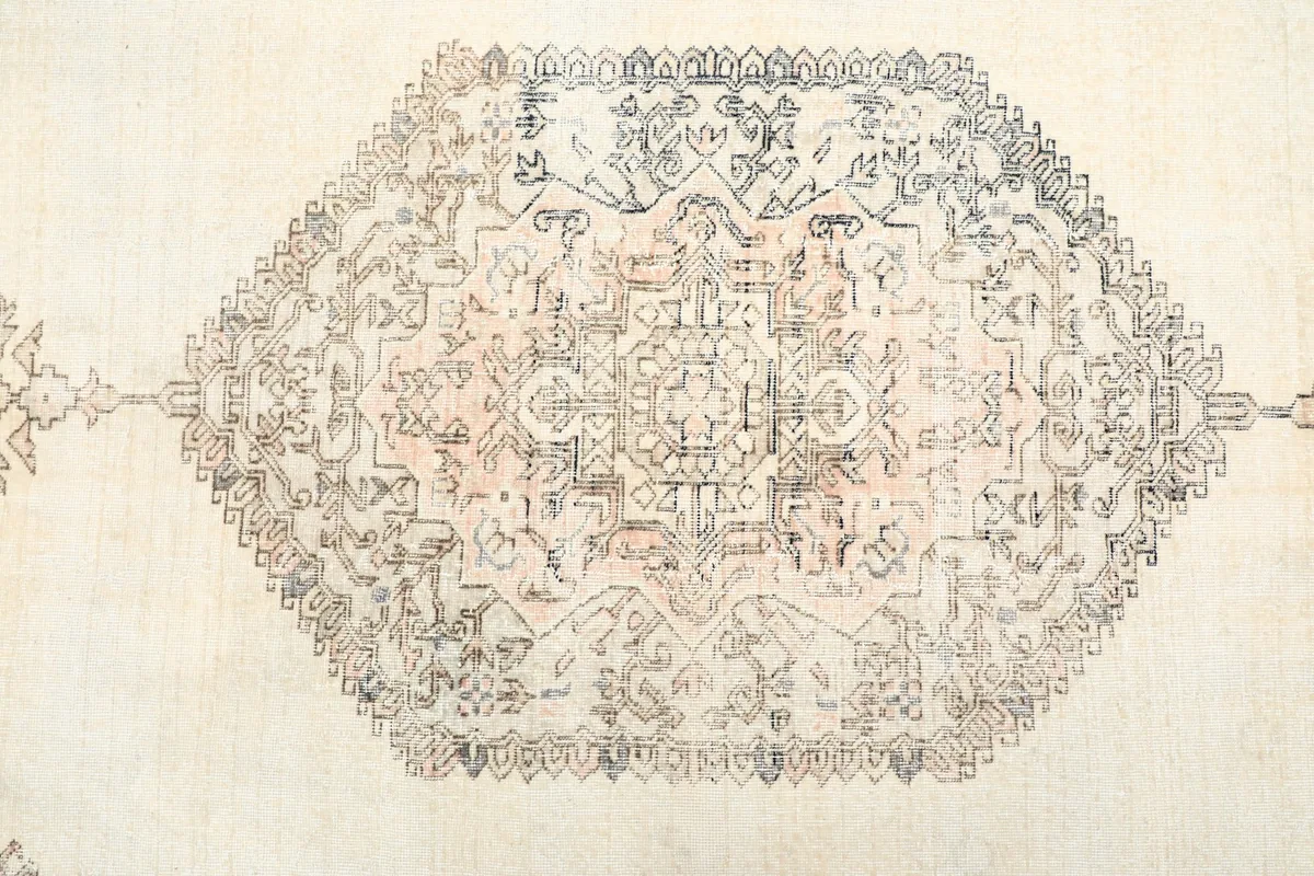 Detailed overhead view of the central medallion design on the ivory field.