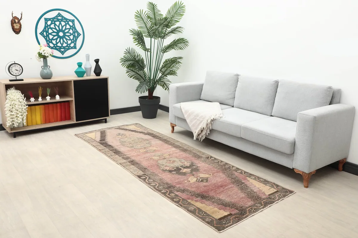 Wide shot of the rose geometric runner rug placed in a living area with furniture