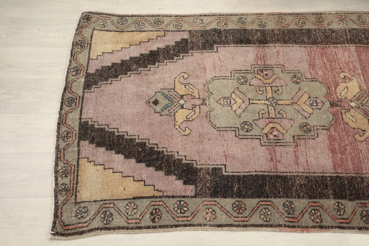 Detail view of the upper section of the runner, highlighting the faded rose and beige patterns