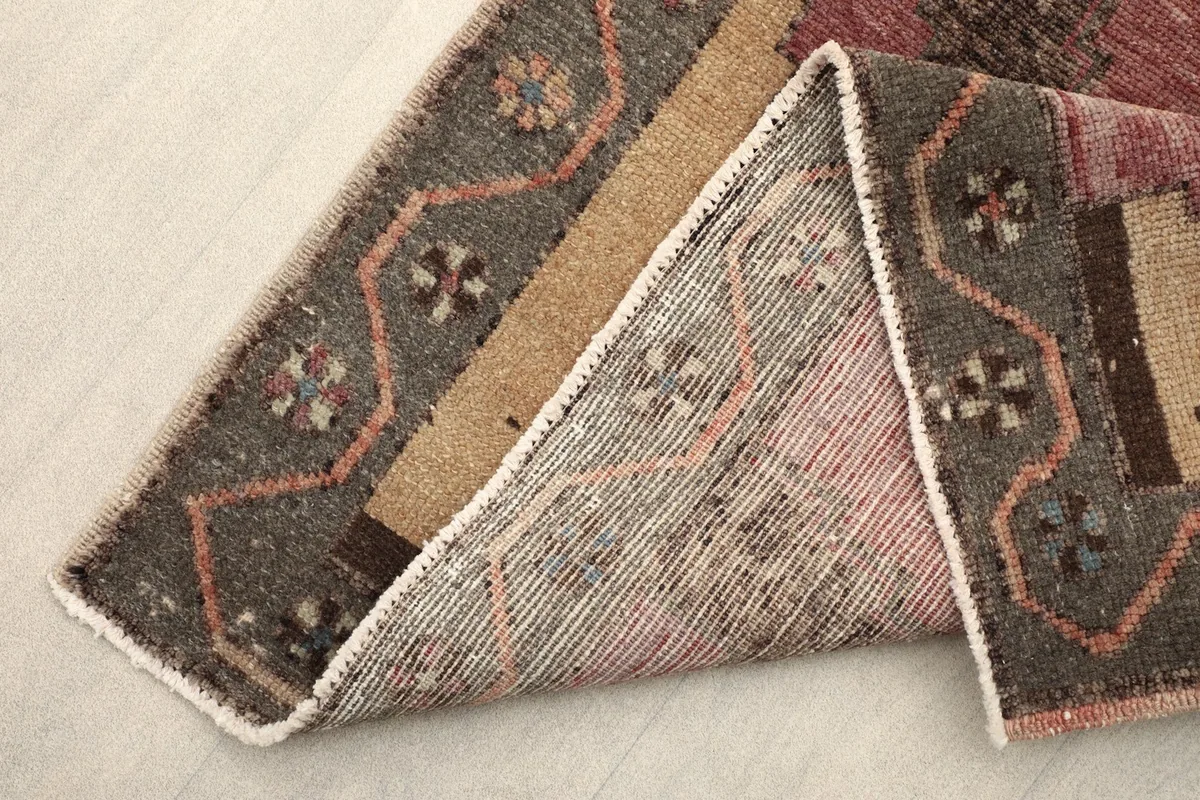 View of the back of the vintage wool runner, showing the hand-knotted cotton foundation