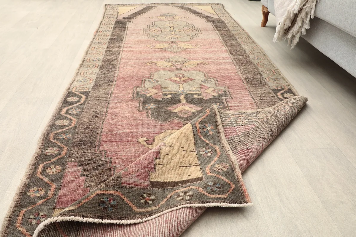 Runner rug partially folded, showing the pile and the overall design in a room