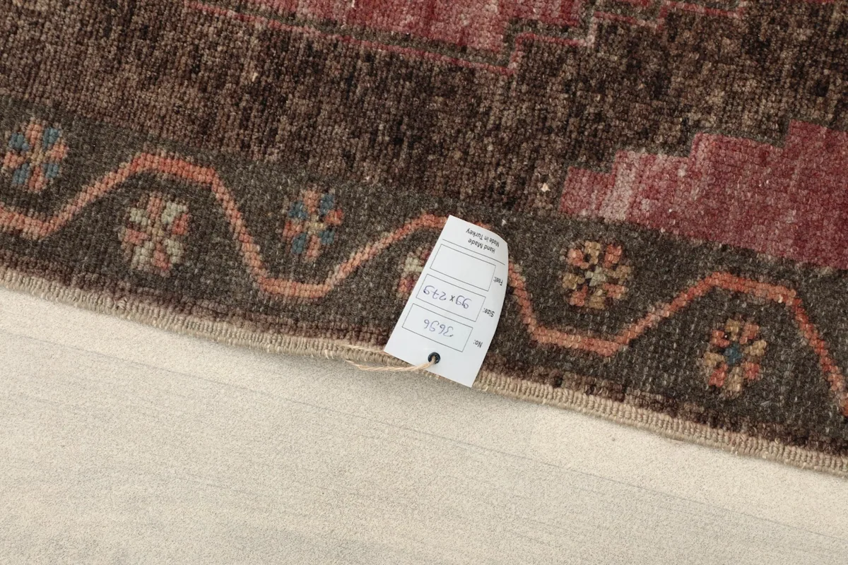 Close-up of the rug's edge and tag, displaying size and material information