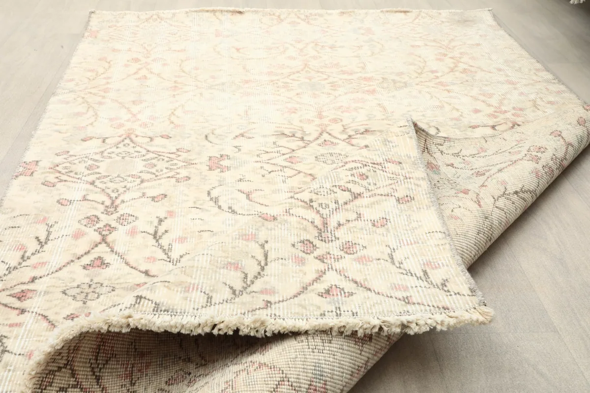 Corner of the rug with its short, natural fringe and the texture of the hand-knotted wool pile.