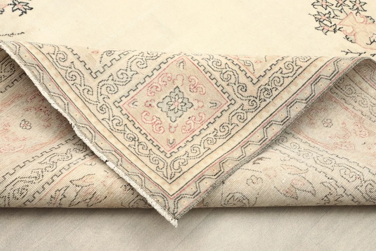 Corner of the rug folded back to show the cotton foundation and hand-knotted construction