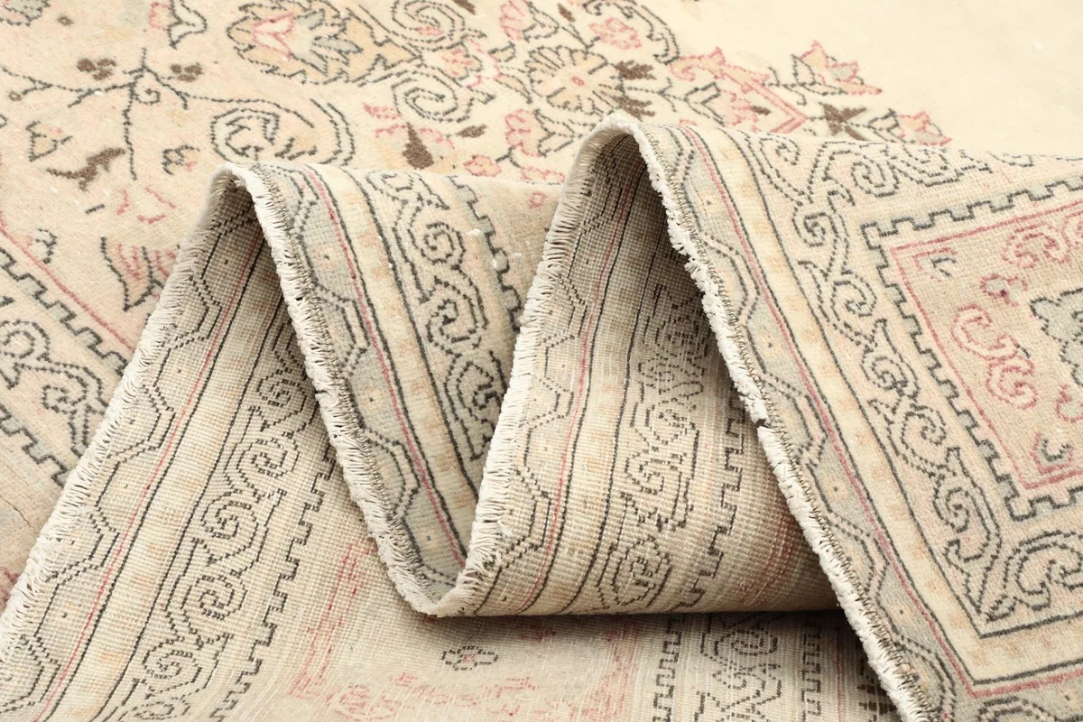 Folded section of the rug, illustrating the soft wool pile and detailed border patterns