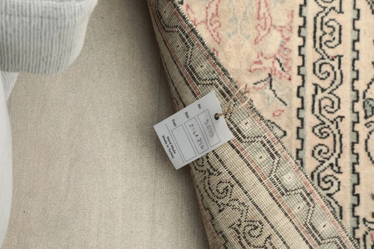 Close-up of the rug's back with a product tag, indicating its origin and material