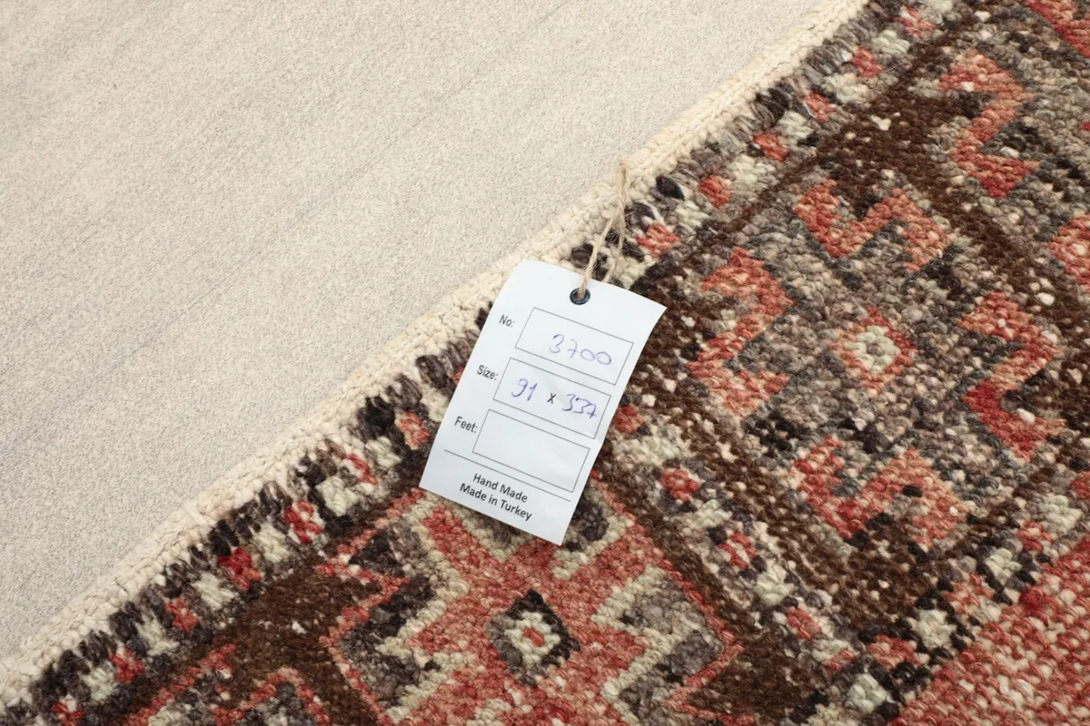 View of the rug's cotton foundation and hand-knotted construction from the back with tag