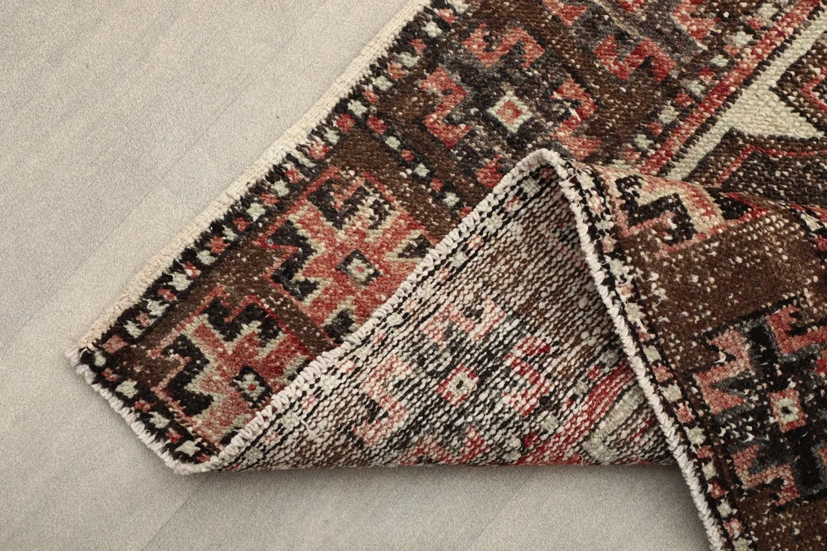 Corner of the runner rug folded to show the back and foundation