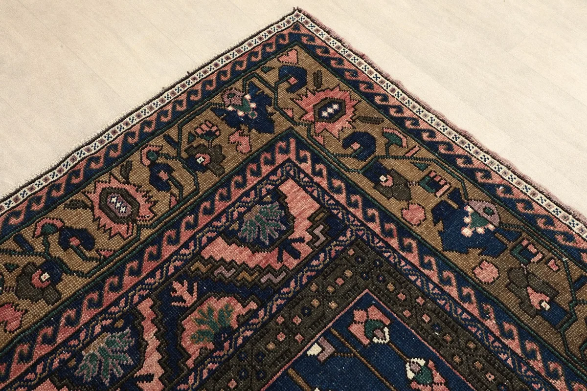 Corner view of the hand-knotted rug, highlighting the multi-layered border design