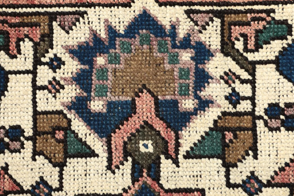 Extreme close-up showing the individual knots and texture of the wool pile in a motif