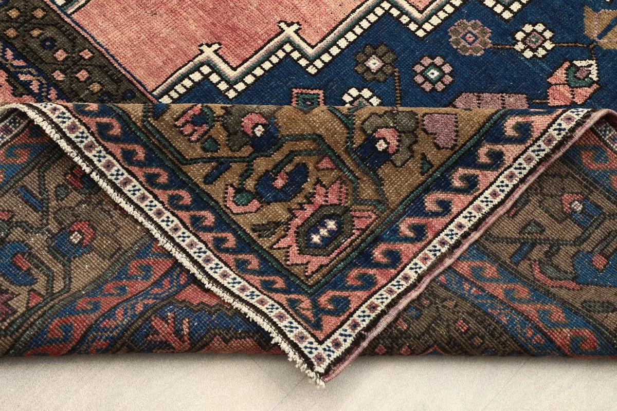 Folded corner of the rug revealing the backside and construction of the hand-knotted piece