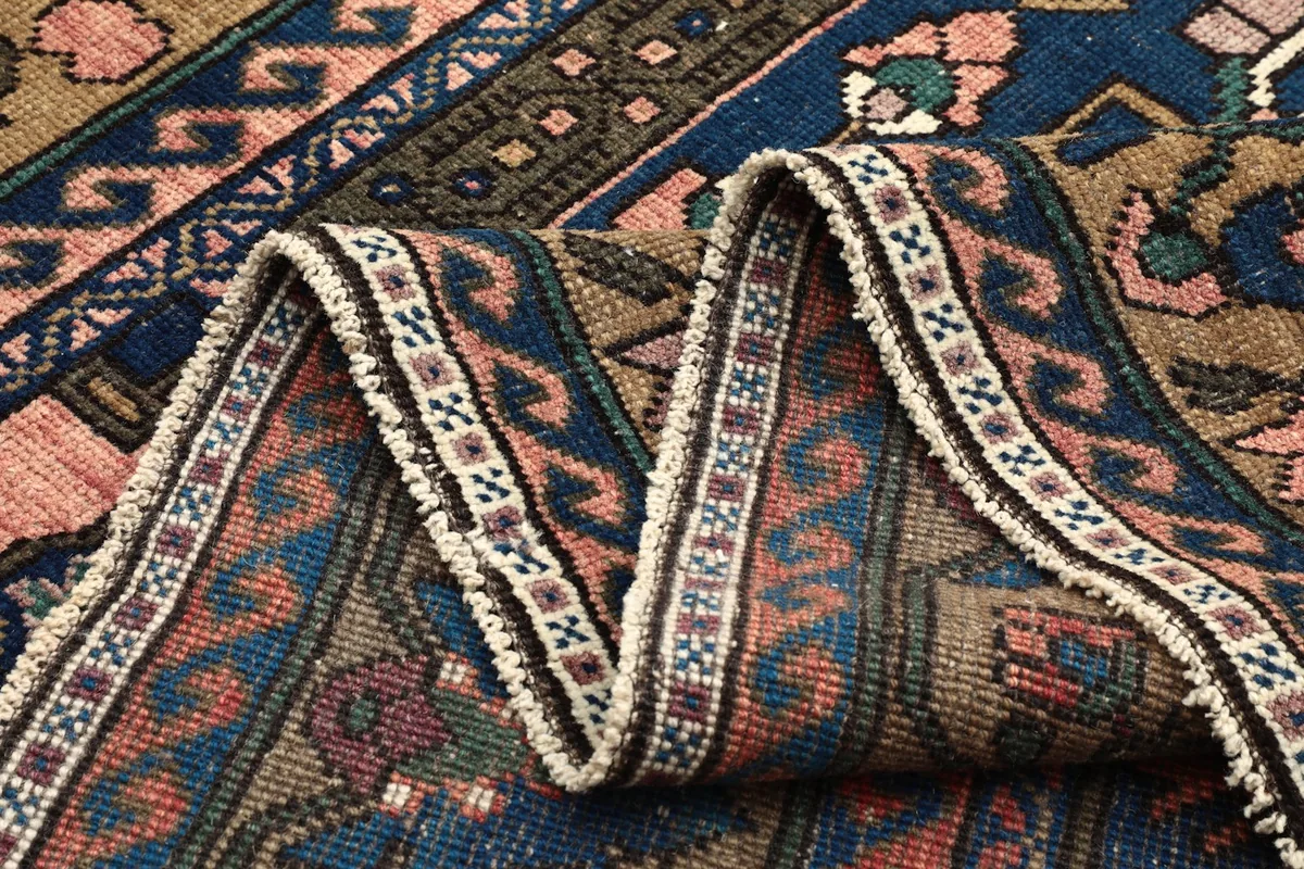 Close-up of the rug's folds, showing the thickness and flexibility of the vintage wool material