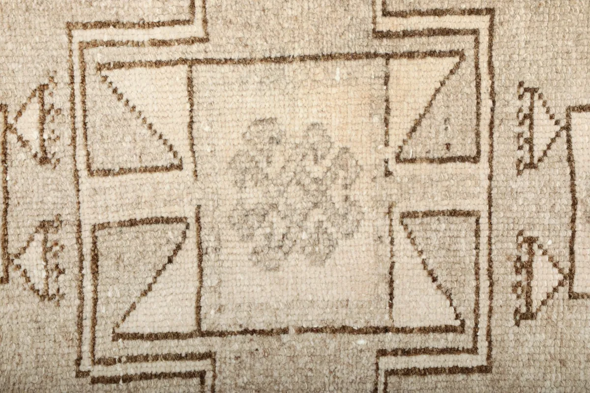 Close-up of a specific geometric element within the rug's pattern, showing the weave and slight color shifts.