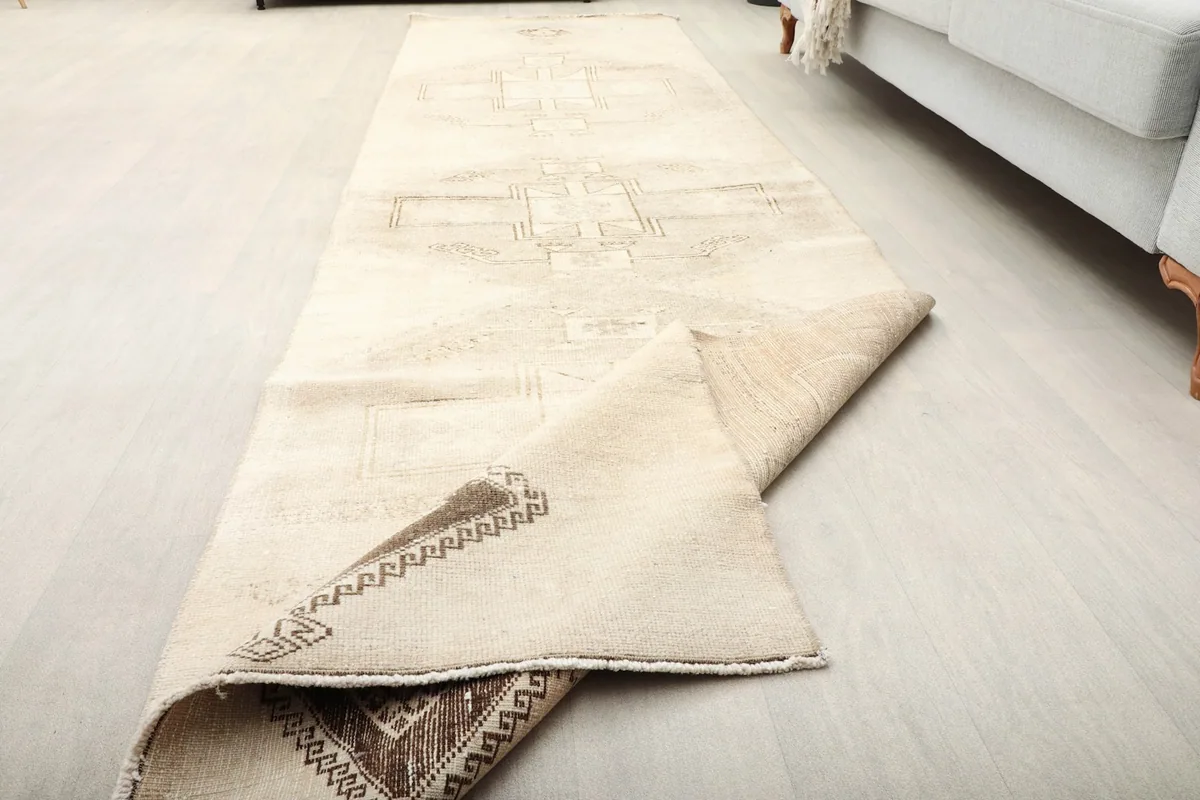 The runner rug partially folded, demonstrating its flexibility and the consistency of the wool pile.