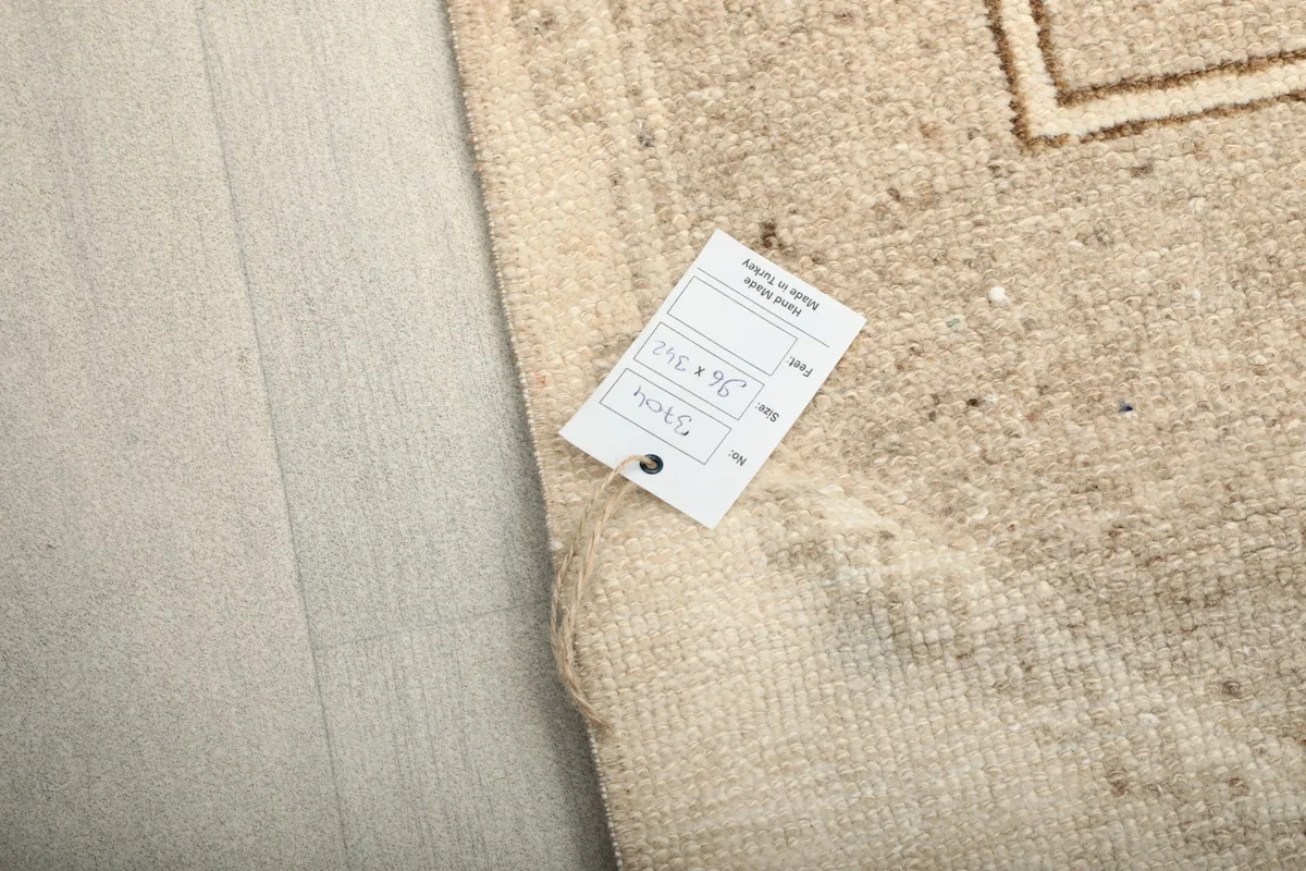 Image showing the product tag with size and other details, resting on the rug's surface.