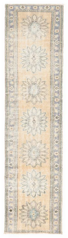 Full overhead view of the beige and blue floral Anatolian runner rug on a white background.