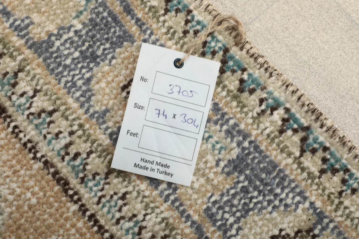 Tag displaying the rug's dimensions (74 x 304 cm) and origin, placed on the back of the rug.