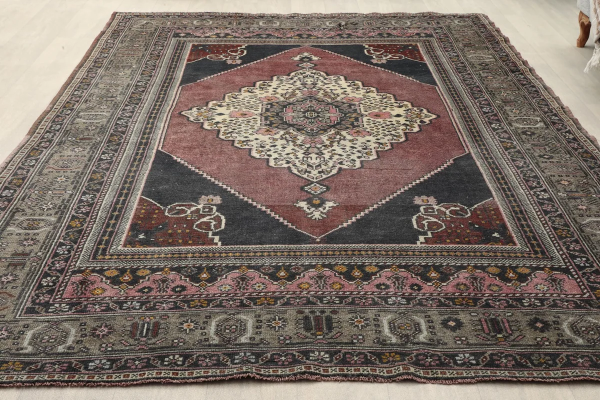 Angled view of the rust and rose medallion rug, highlighting border details and colors