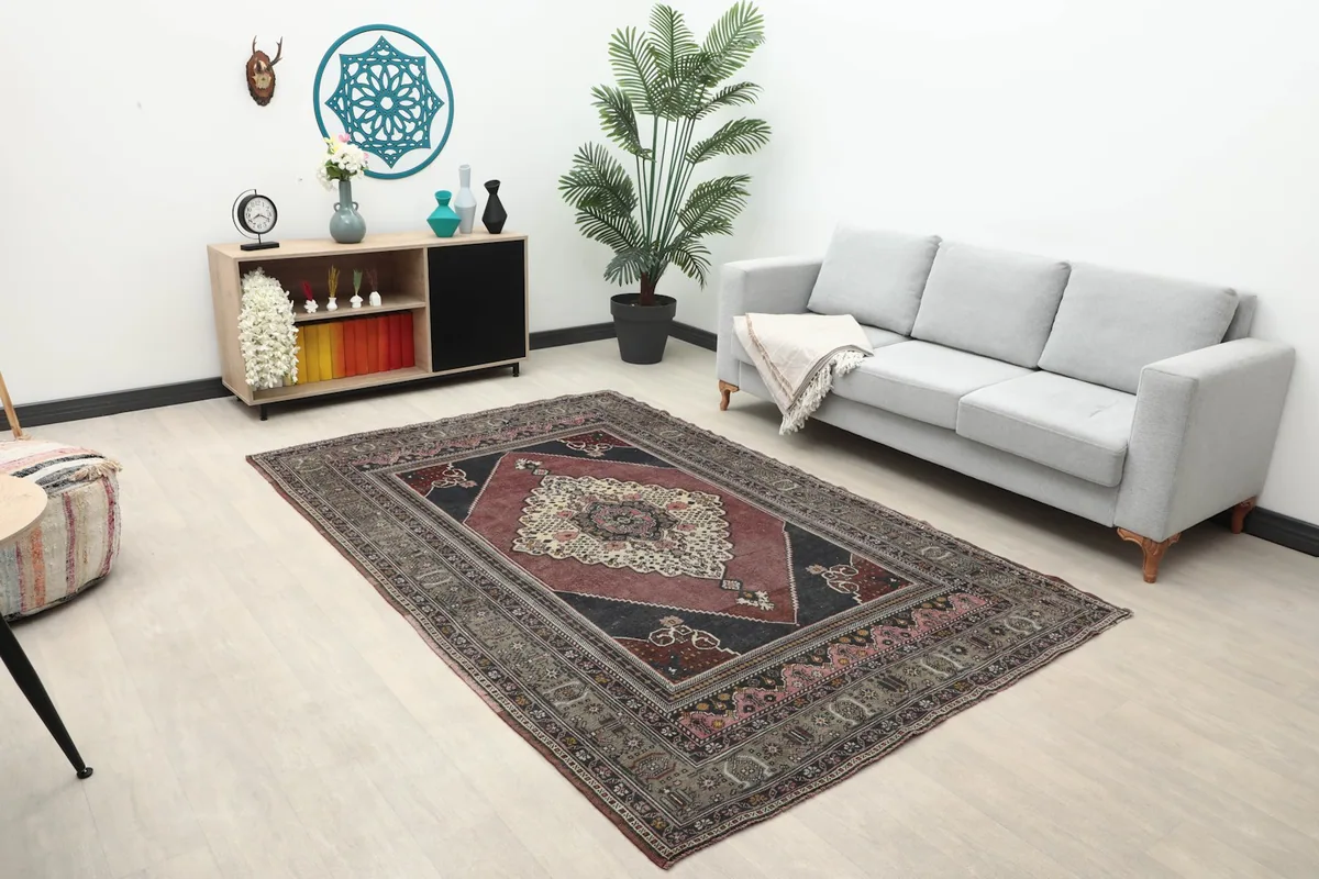 Full room view of the rug with sofa and decor, showing its medium size and placement