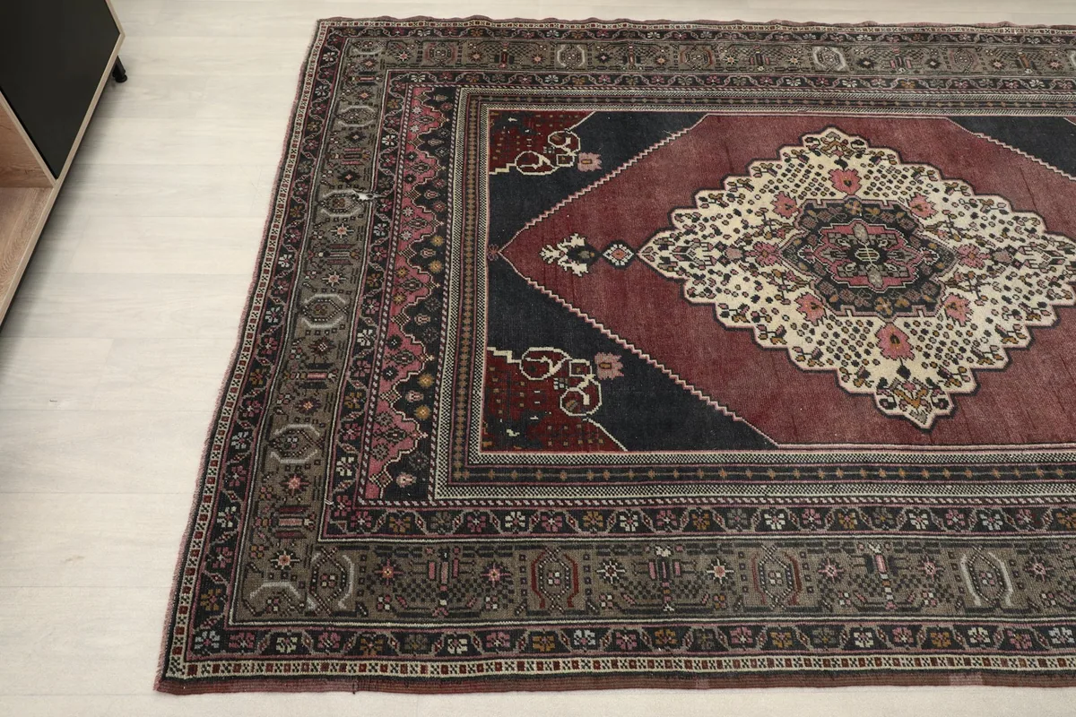 Close-up of the rug's border and field, showcasing the interplay of rust, black, and gray patterns