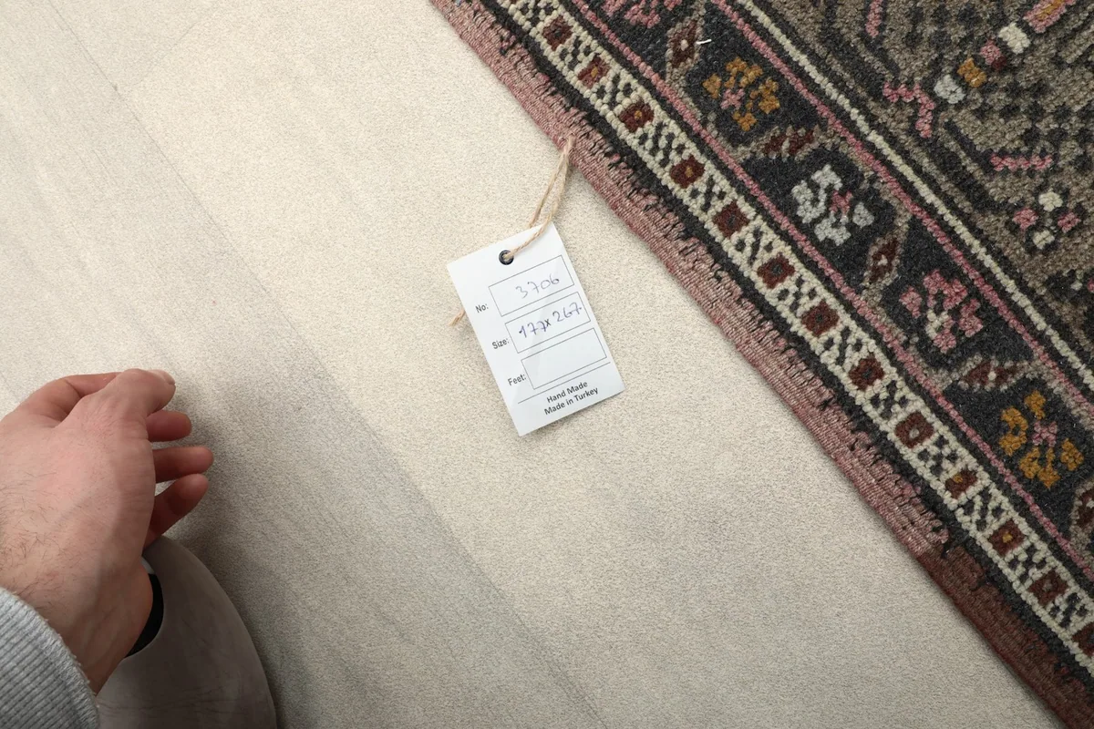 Close-up of the rug's edge with a product tag, indicating size and material details
