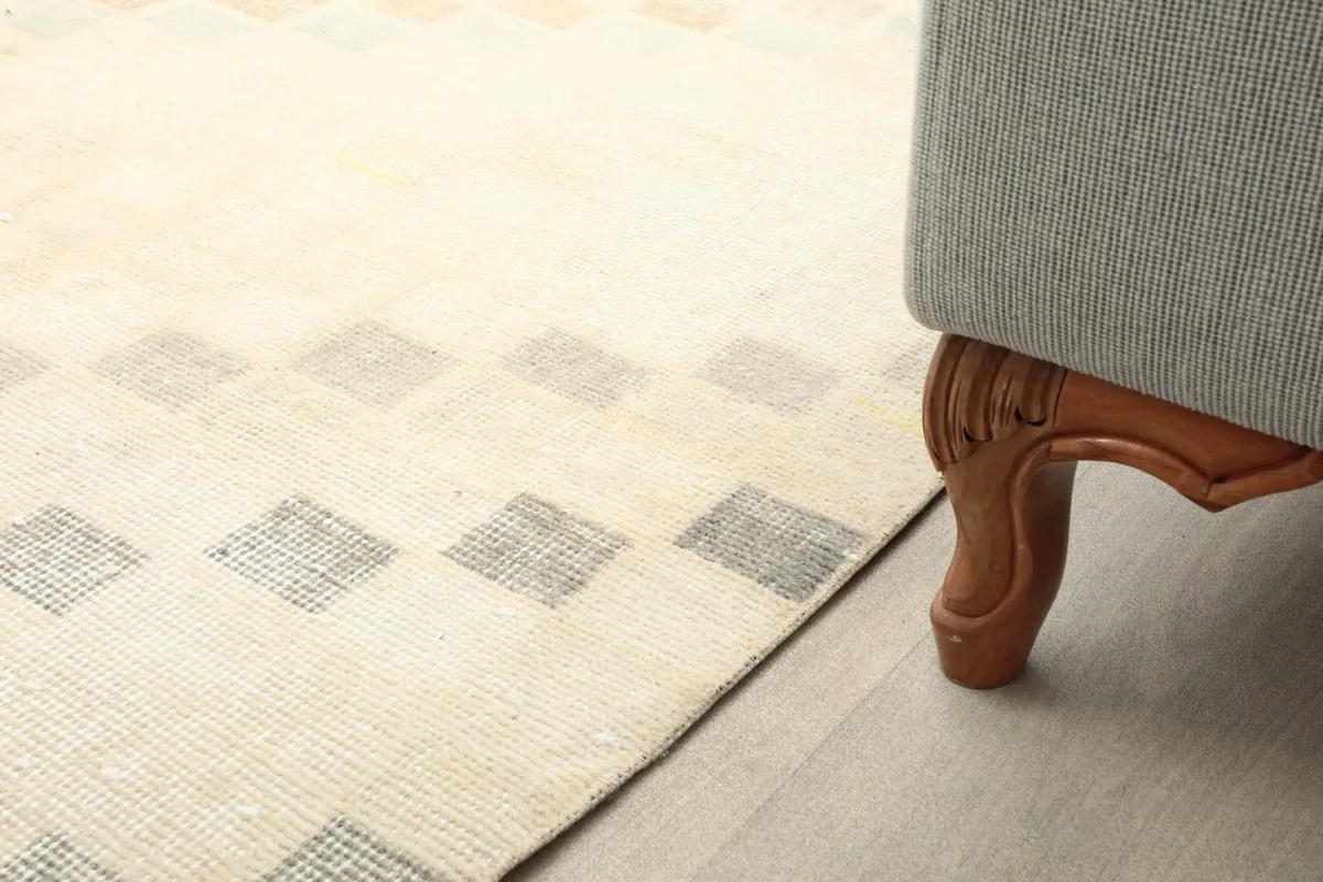 Close-up of the rug next to a sofa leg, showing its placement in a room