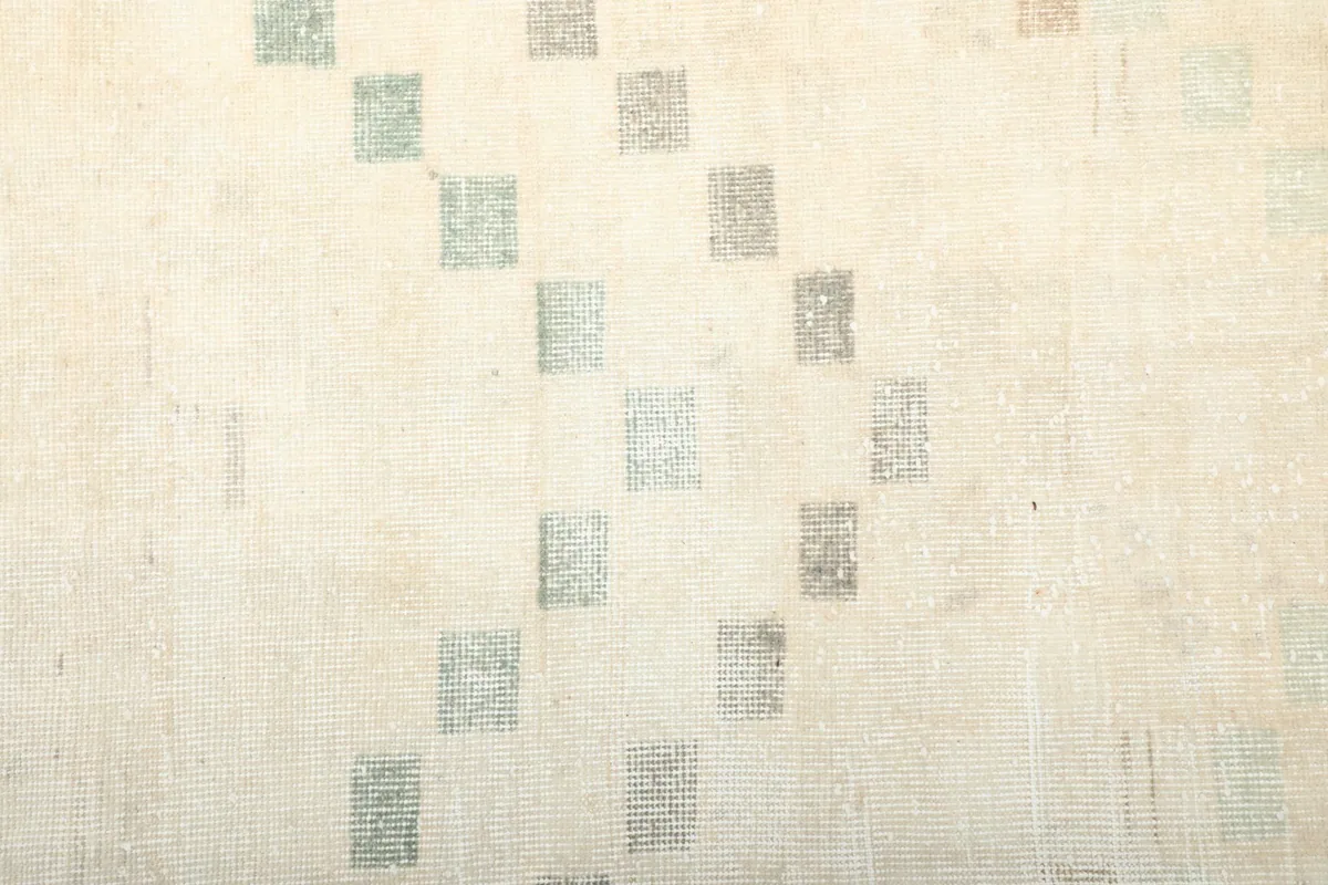 Detailed view of the low wool pile and individual gray and blue squares in the pattern