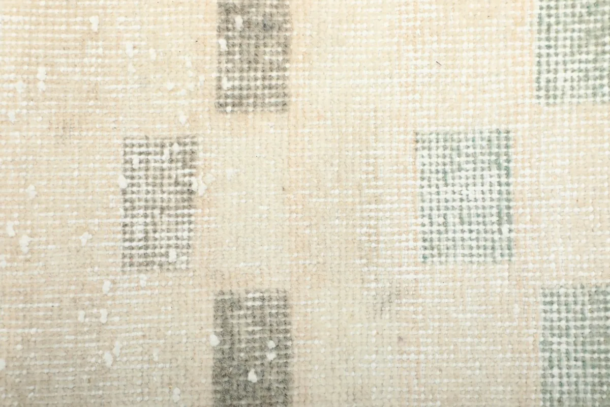 Close-up showcasing the texture of the wool pile and subtle wear on the geometric squares
