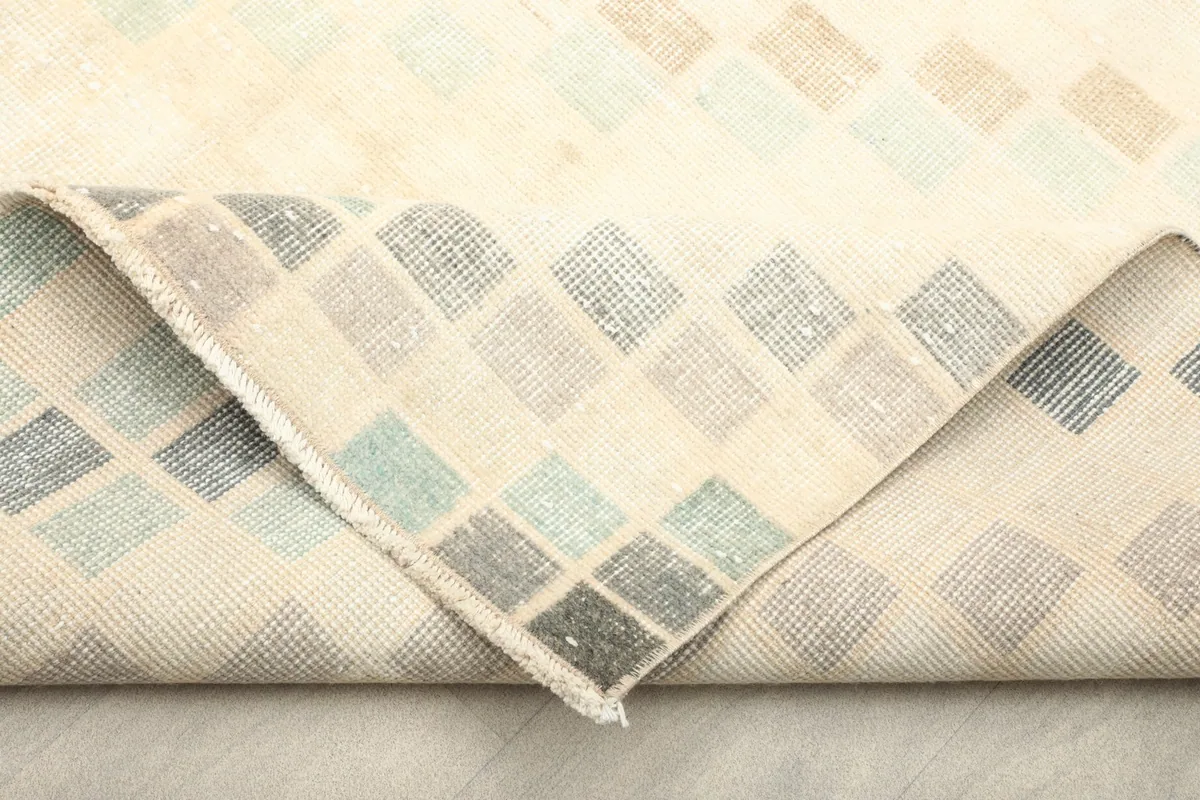 View of the rug's cotton foundation and the reverse side of the hand-knotted wool pile
