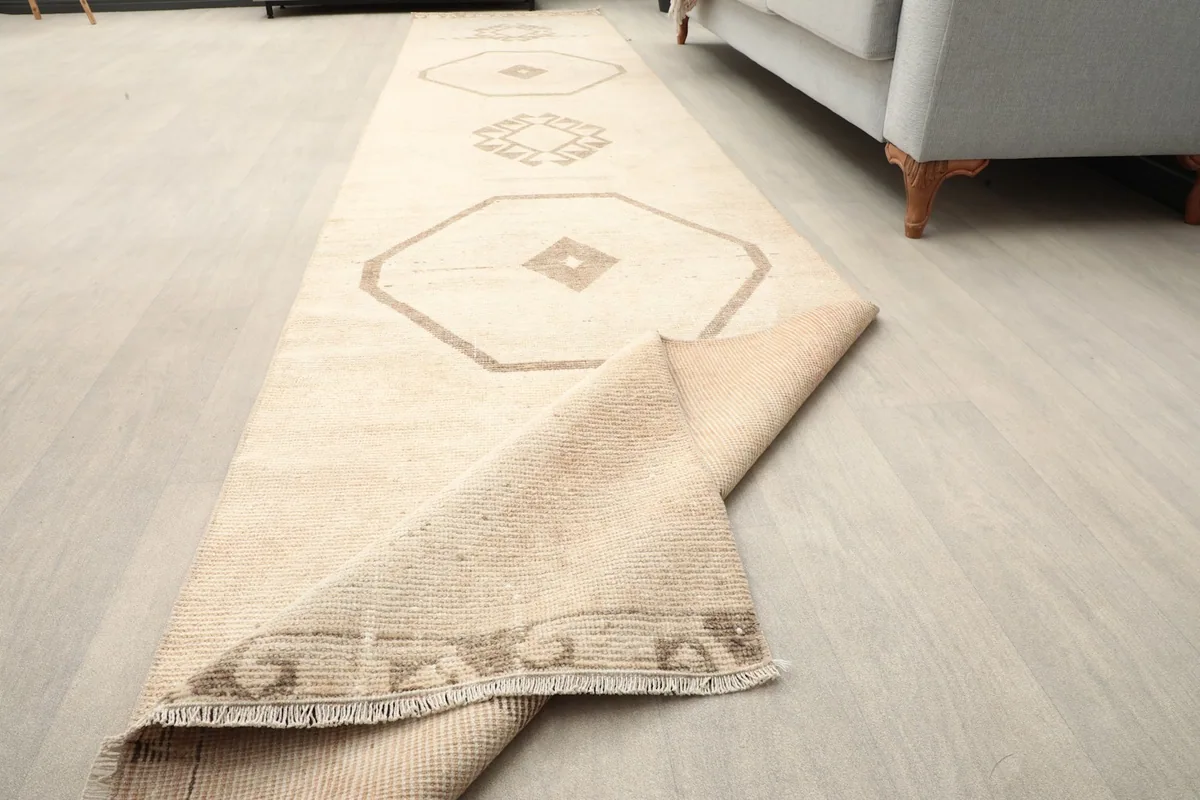 Runner rug partially rolled, showing flexibility and the fringe detail.
