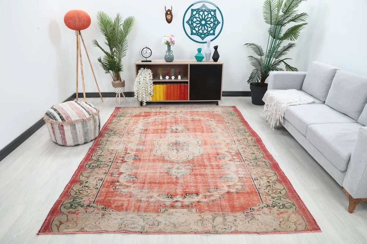 Vintage rust area rug displayed in a living room setting with a sofa and decor.