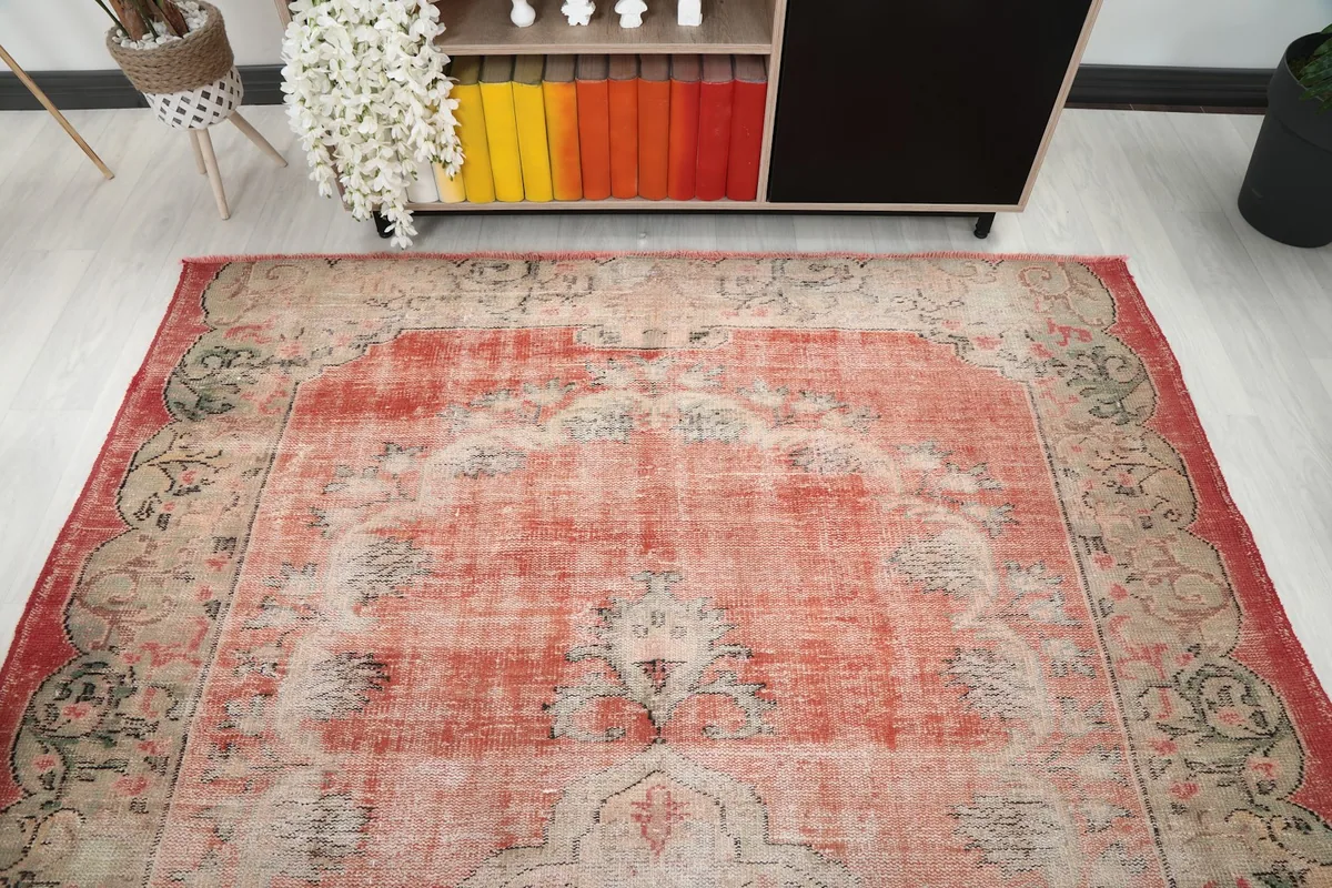 Overhead view of the vintage rust rug, highlighting the full medallion and border.