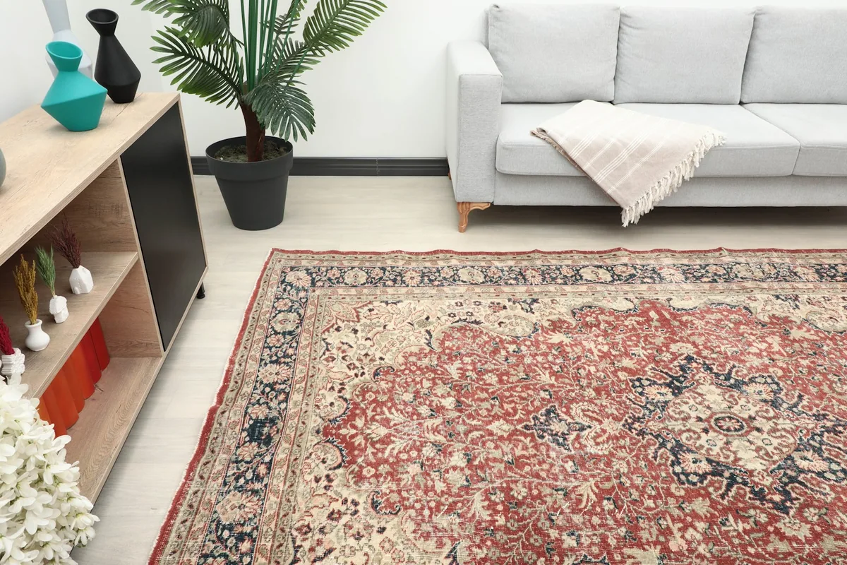 Angled view of the red floral rug in a room, highlighting its placement